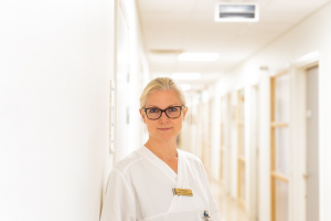 Foto av Åsa Petersén i läkarkläder i en sjukhuskorridor